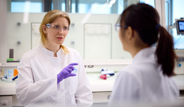 Zwei Frauen unterhalten sich im Labor über ihre Arbeit